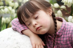 Portrait of beautiful young girl sleeping outside on flowers background